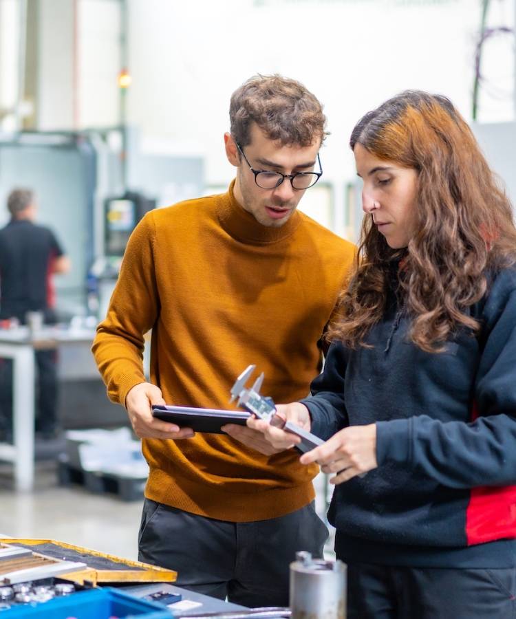 Engineers check the quality of a metal piece generated on a cnc modern factory
